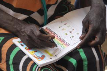 A CHW filling in the patient register