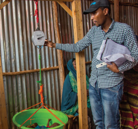 Weighing an infant at a UNICEF-supported outpatient therapeutic centre in Kabasa IDP camp, Dolow, Somalia