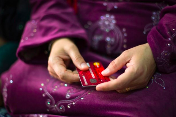 A woman holds an electronic food card in Akçakale camp, Sanliurfa Province, Turkey, 2018