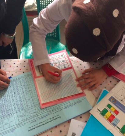 Health worker plotting anthropometric indicators on a child health card, Herat Province, Afghanistan, June 2016