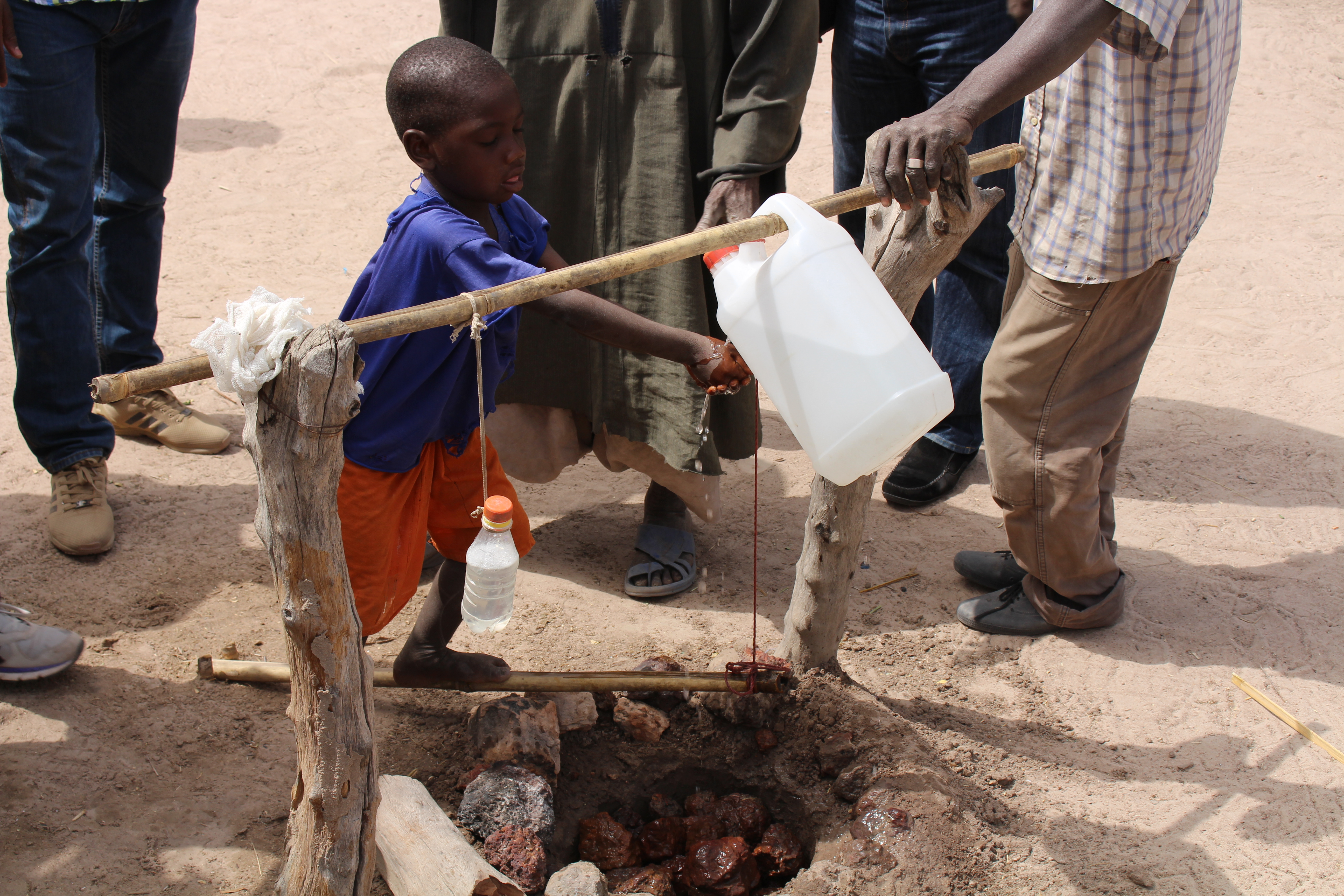 Image shows a child washing their hands at a washing station.