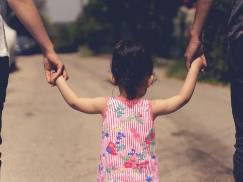 A girl holding hands with people on either side