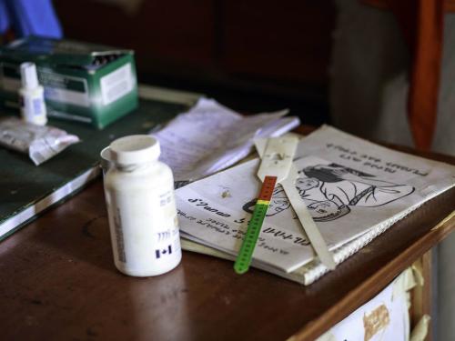 A medical professional's desk with medication, books and equipment