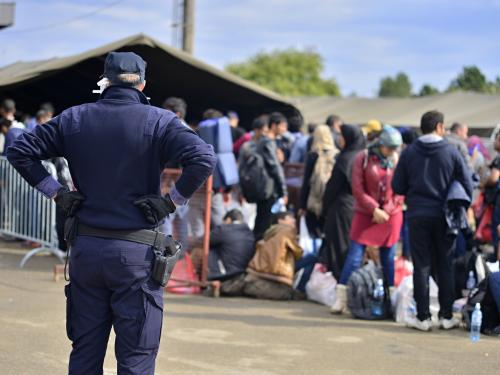 A worker watching refugees line up to go to a camp