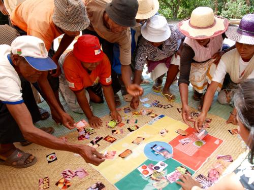FB figures gathered round a mat placing photographs