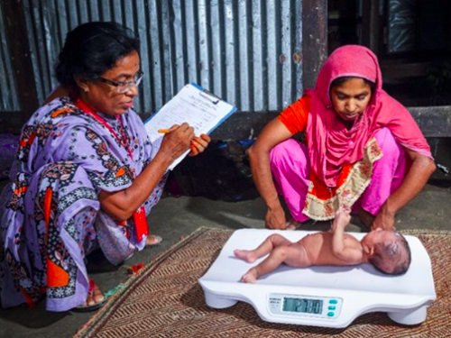 FB field research officers measure the weight of an infant under six monts in Barisal Bangladesh 2016