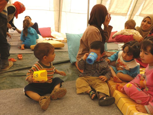 children and adults in a tent