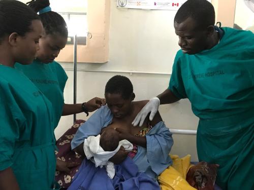 three doctors supervise a woman breastfeeding