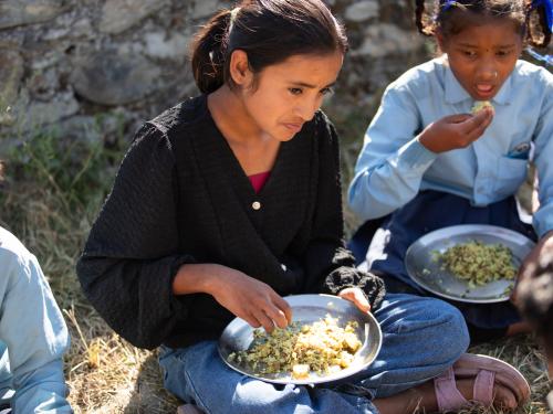 Two school girls eating lunch.