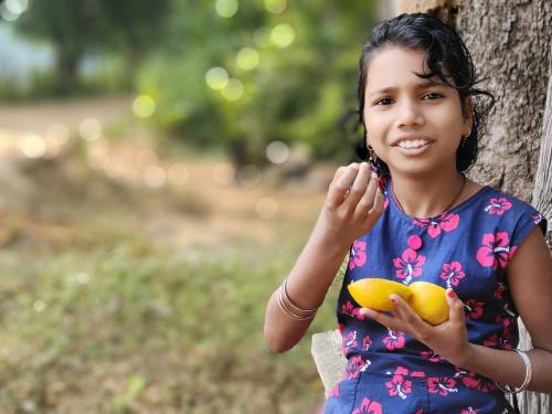 Indian girl eating an orange