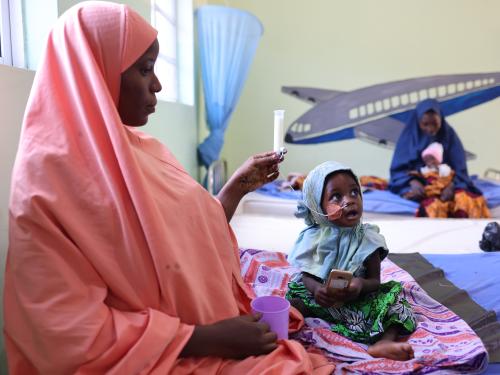 A mother feeding her child with therapeutic milk through a nasogastric tube