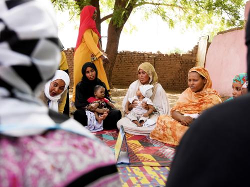 Women sit in a circle with their babies in their laps