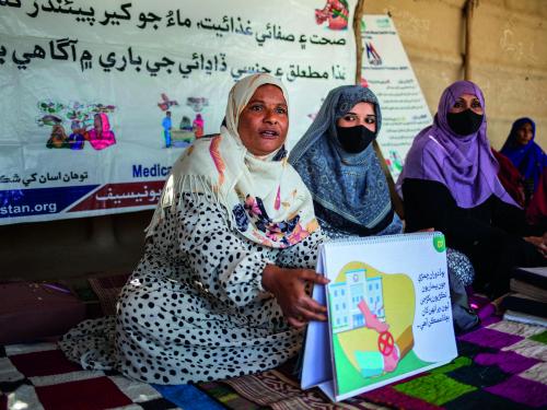Three women holding illustrative cards