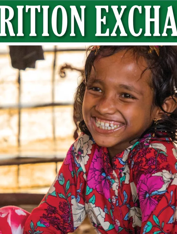 Front cover of Nutrition Exchange English version of issue 10. Image shows a young girl eating from bowl and smiling.