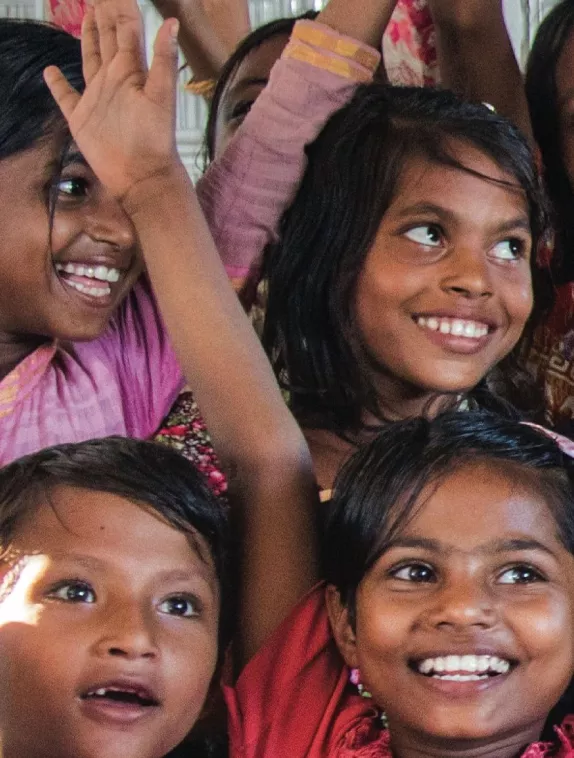 Front cover of Issue 13 English version titled, "Stories from the SUN Movement Global Gathering 2019." The image shows young girls smiling with their hands in the air.