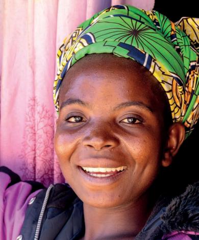 Front cover of technical briefing paper on women's nutrition titled, "Women's nutrition: a summary of evidence, policy and practice including adolescent and maternal life stages." The cover shows a woman standing and smiling at the camera.