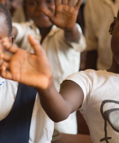 Smiling young girls raising their hands