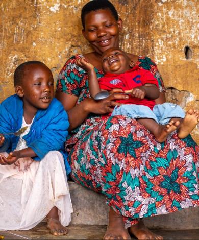 Woman feeding two children with a spoon