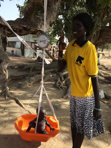 a woman uses a scale to weigh a baby