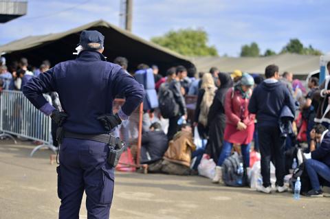 A worker watching refugees line up to go to a camp