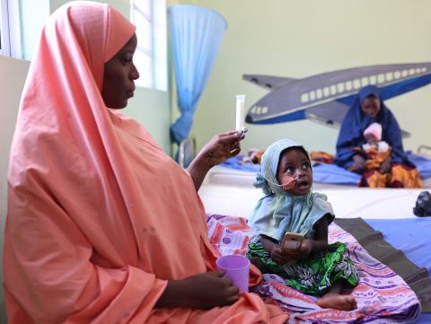 A mother feeding her child with therapeutic milk through a nasogastric tube