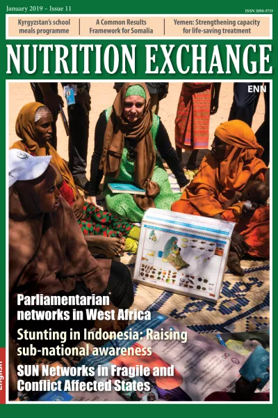Front cover of Issue 11 English. Image shows a group of women sitting and learning about nutrition.